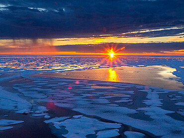 Sunset and rain showers in the heavy pack ice in McClintock Channel, Northwest Passage, Nunavut, Canada, North America