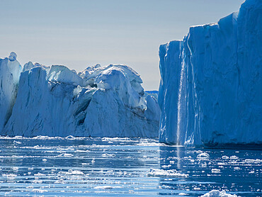 A waterfall from melting icebergs from the Ilulissat Icefjord just outside the city of Ilulissat, Greenland, Denmark, Polar Regions