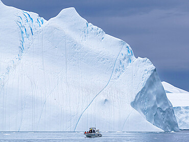 Tourists taking an ice tour in a small boat watching icebergs from the Ilulissat Icefjord, just outside Ilulissat, Greenland, Denmark, Polar Regions