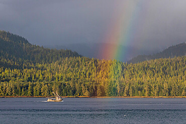 Commercial fishing boat with a rainbow in Behm Canal, Southeast Alaska, USA.