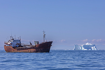 Freighter near iceberg from the nearby Ilulissat Icefjord floating near Ilulissat, Western Greenland, Polar Regions