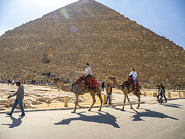 Tourist on a camel ride in front of the Great Pyramid of Giza, the oldest of the Seven Wonders of the World, UNESCO World Heritage Site, near Cairo, Egypt, North Africa, Africa