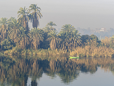 Fishermen in a small boat on the upper Nile River, amongst some of the most verdant land along the river, Egypt, North Africa, Africa