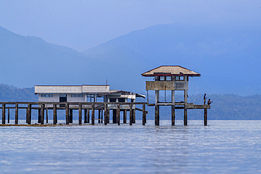 Young men fishing from a local building on Bangka Island, off the northeastern tip of Sulawesi, Indonesia, Southeast Asia, Asia