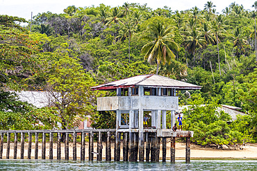 Young men fishing from a local building on Bangka Island, off the northeastern tip of Sulawesi, Indonesia, Southeast Asia, Asia