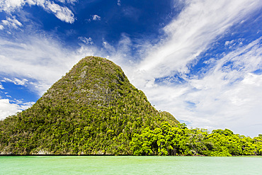 A view of islets covered in vegetation from inside the natural protected harbor in Wayag Bay, Raja Ampat, Indonesia, Southeast Asia, Asia