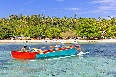 Local fisherman in outrigger boat in the shallow reefs off Bangka Island, off the northeastern tip of Sulawesi, Indonesia, Southeast Asia, Asia