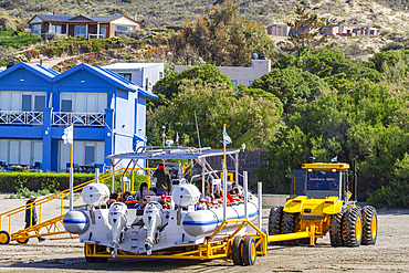 A commercial whale watching boat being launched at the beach at low tide in Puerto Pyramides, Golfo Nuevo, Argentina, South America