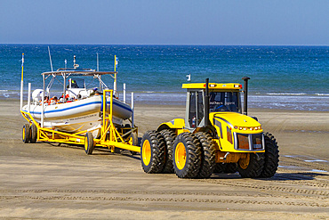 A commercial whale watching boat being launched at the beach at low tide in Puerto Pyramides, Golfo Nuevo, Argentina, South America