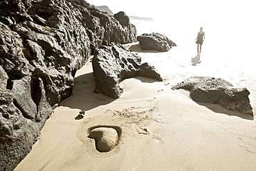 Young woman at beach near heart shaped, Fuerteventura, Spain