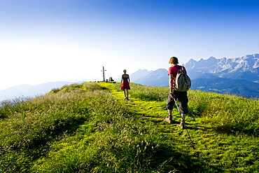 Hikers arriving summit cross of Gasselhoehe, Schladminger Tauern, Styria, Austria