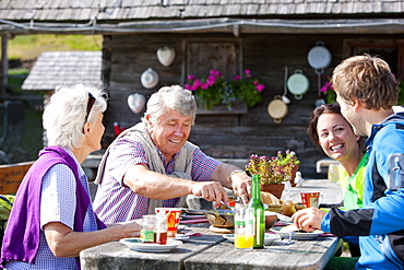 Four hikers having a snack in front of an alpine hut, Styria, Austria