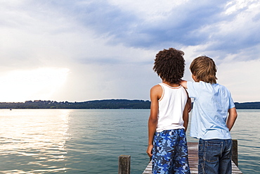 Two boys on a jetty at lake Starnberg, Upper Bavaria, Germany