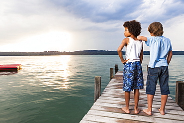 Two boys on a jetty at lake Starnberg, Upper Bavaria, Germany