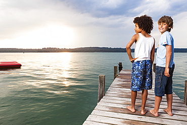 Two boys on a jetty at lake Starnberg, Upper Bavaria, Germany