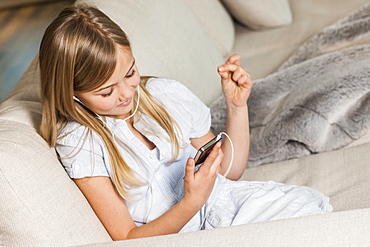 Girl with mp3 player listening to music, Hamburg, Germany