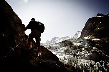 Hiker on mountain trail, on the way to Schreckhorn hut, Lower Grindelwald glacier, Bernese Oberland, Switzerland