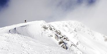 Hiker climbing on a snowy peak, ascend to Unnutz Mountain (2078 m), Rofan Mountains, Tyrol, Austria