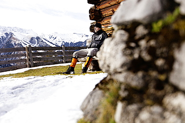 Hiker taking a rest, Wooden alpine hut, descent from Unnutz Mountain (2078 m), Rofan Mountains, Tyrol, Austria