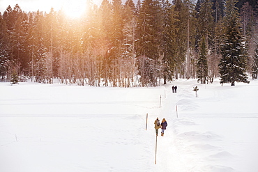 Two young women walking in snow, Spitzingsee, Upper Bavaria, Germany