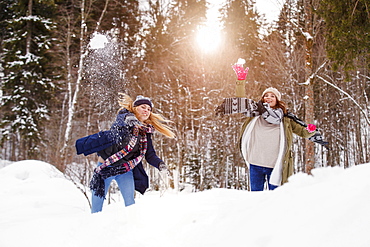 Two young women throwing snowballs, Spitzingsee, Upper Bavaria, Germany