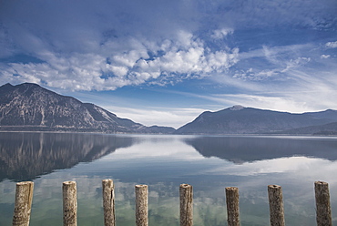 Wooden poles on the shore of lake Walchensee at low tide overlooking the Herzogstand, Walchensee, Alps, Bavaria, Germany