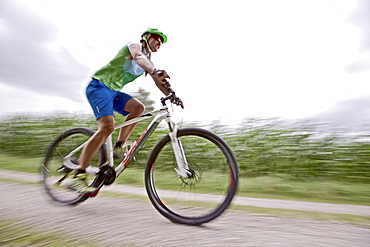 Woman bicycling, Chiemgau, Bavaria, Germany