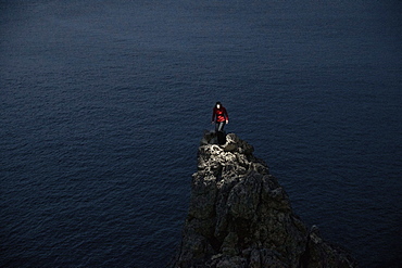 Young woman standing on a spiky rock at the sea, Mallorca, Spain