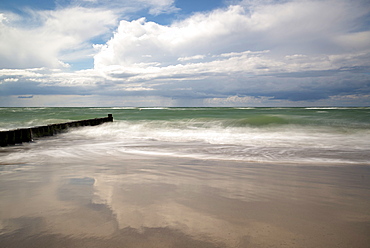 Long exposure of a cloudy sky and the Baltic Sea with groynes in the Western Pomerania Lagoon Area National Park, Ahrenshoop, Fischland-Darß-Zingst, Mecklenburg-Western Pomerania, Germany