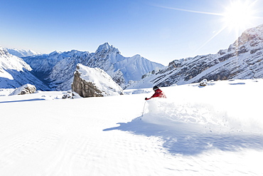 skier in deep powder snow, Zugspitze, overlooking Reintal Valley and Hochwanner, Upper Bavaria, Germany