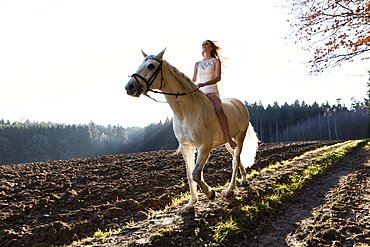 girl in white dress horseback-riding, Freising, Bavaria, Germany