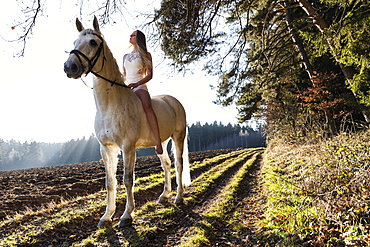 girl in a white dress riding her horse, Freising, Bavaria, Germany