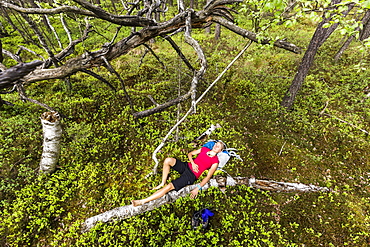 young woman resting in a moorland forest, Berg at Lake Starnberg, Upper Bavaria, Germany