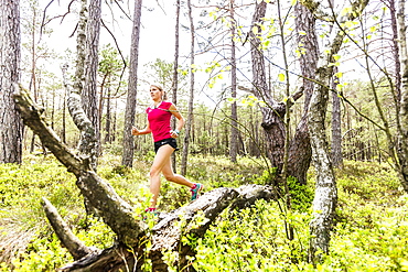 young woman running in a moorland forest, Berg at Lake Starnberg, Upper Bavaria, Germany