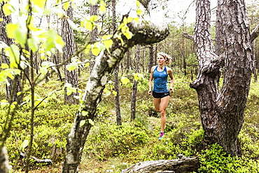 young woman running in a moorland forest, Berg at Lake Starnberg, Upper Bavaria, Germany