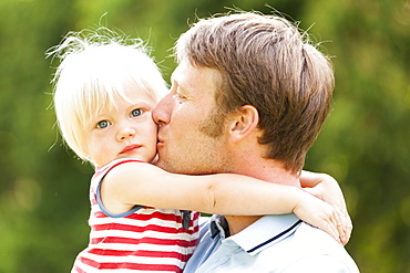 young father kissing his two-year-old daughter, Speyer, Rheinland-Pfalz, Germany