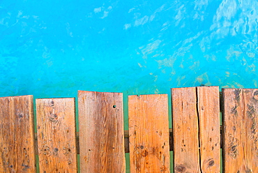 Detailed view from the top view of a wooden pier with turquoise water. Playa de Muro beach, Alcudia, Mallorca, Balearic Islands, Spain