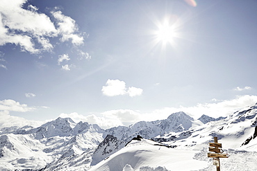 Signpost and sunny snowy mountains and ski resort, Schnalstaler Glacier, South Tirol, Italy