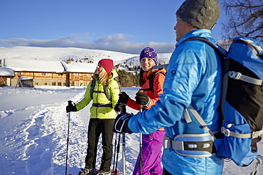 Group of people snow shoeing in front of a mountain hut, Kreuzwiesenalm, Luesen, South Tyrol, Italy