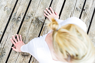 woman doing yoga on the wooden jetty, sun salute, Kirchsee, Bad Toelz, Bavaria, Germany