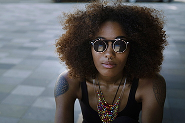 Young afro-american woman with backpack at Lenbachplatz, Munich, Bavaria, Germany