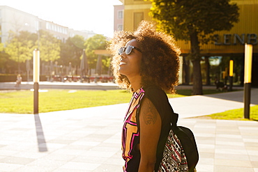 Young afro-american woman with backpack at Lenbachplatz, Munich, Bavaria, Germany