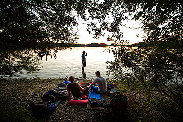 Three young men camping at a lake, Freilassing, Bavaria, Germany