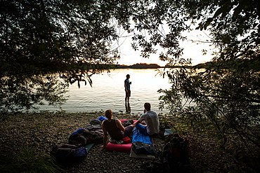 Three young men camping at a lake, Freilassing, Bavaria, Germany