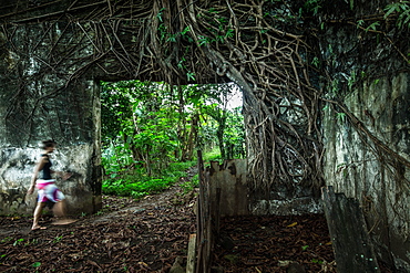 Young woman walking through an overgrown ruin, Sao Tome, Sao Tome and Principe, Africa