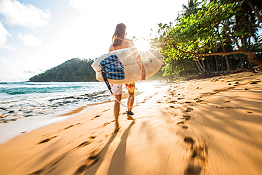 Young female surfer walking along the beach, Sao Tome, Sao Tome and Principe, Africa