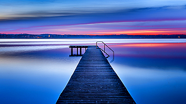 Jetty on Lake Starnberg at sunset with a view of the mountains, St. Heinrich, Bavaria, Germany