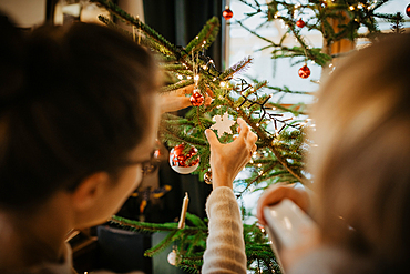 Mother decorates Christmas tree with her son, family, Christmas