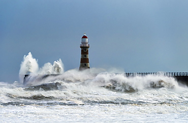 Roker Lighthouse and waves from the River Ware crashing onto the pier, Sunderland, Tyne and Wear, England