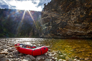 Packraft on the banks of the Charley River, sun going down behind ridge in background, Yukon-Charley Rivers National Preserve, Alaska, United States of America